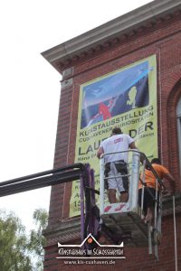 Nana Bastrup und Matvey Slavin - Ausstellung Cuxhavener Kuriositäten - Banner aufhängen - Künstlerhaus im Schlossgarten - Cuxhaven